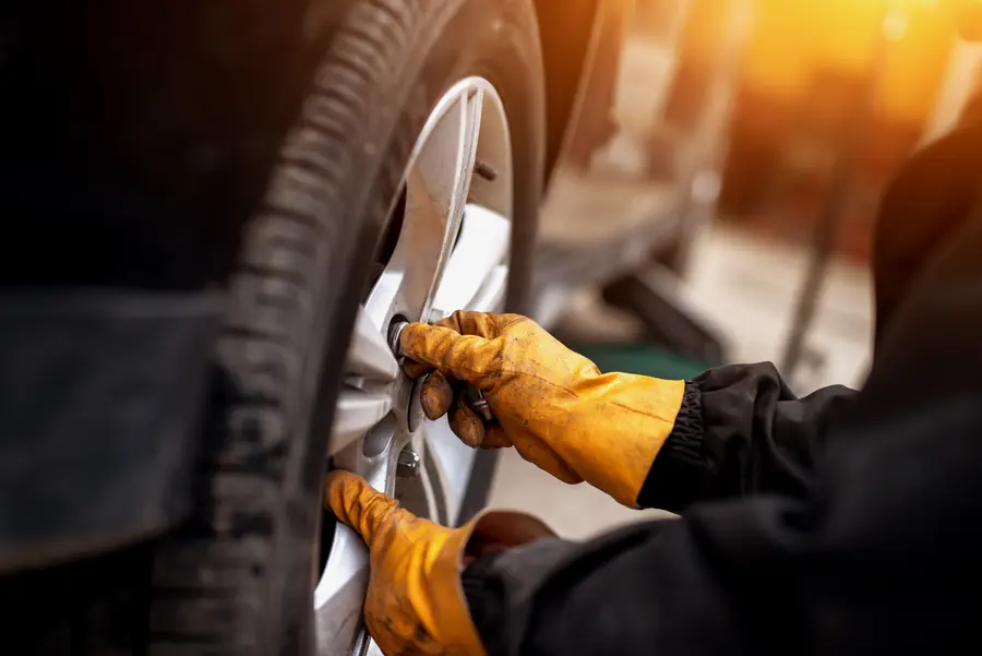 Mecânico com luvas trabalhando em uma roda de carro