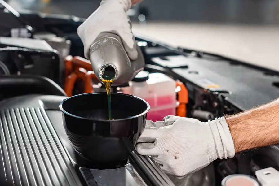 Troca de óleo do motor com funil, em manutenção preventiva